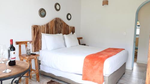 a bedroom with a white bed with a wooden headboard at Casa Hotel Santa Helena Boutique in Villa de Leyva
