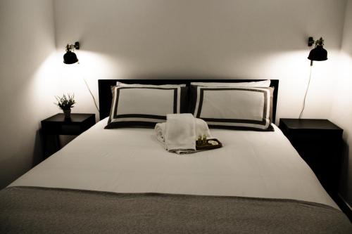 a bed with two pillows and a towel on it at Casas da Avó Bia in Lagos