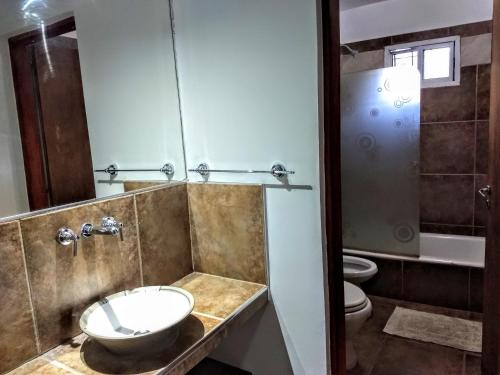 y baño con lavabo y aseo. en Depto, planta baja en Salta