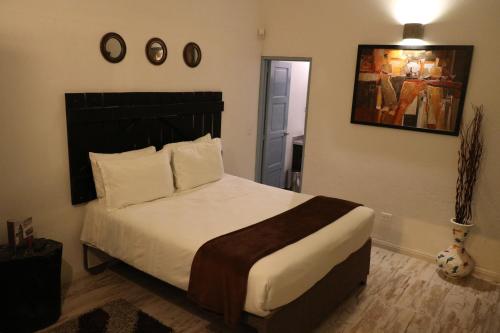 a bedroom with a large bed and a painting on the wall at Casa Hotel Santa Helena Boutique in Villa de Leyva