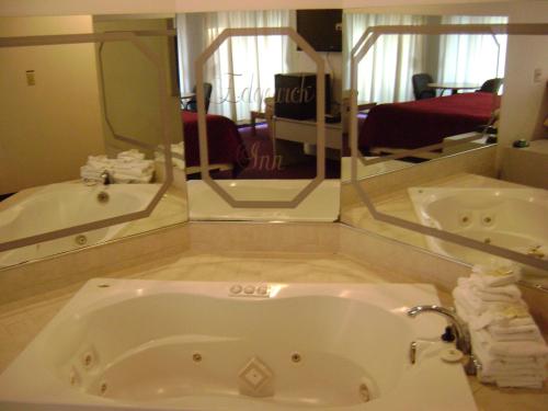a bathroom with a tub and a large mirror at Edgewick Inn in North Bend