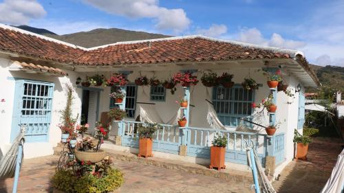 a blue and white house with potted plants at Casa Hotel Santa Helena Boutique in Villa de Leyva
