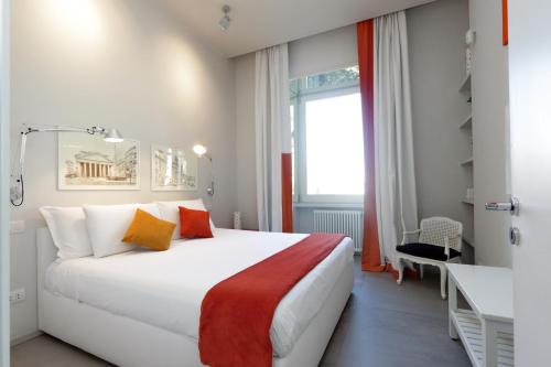 Un dormitorio con una gran cama blanca y una ventana en ROMANCE AL COLOSSEO 2, en Roma