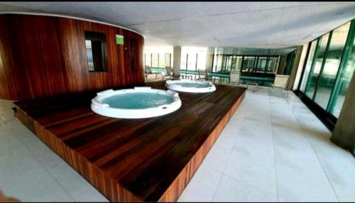 a large bathroom with two large jacuzzi tub at Maravilhoso Apartamento Reserva DNA Ubatuba in Ubatuba
