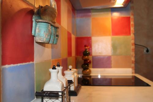 uma cozinha colorida com dois vasos brancos numa parede em Casa Rural La Charolesa em Aguilera