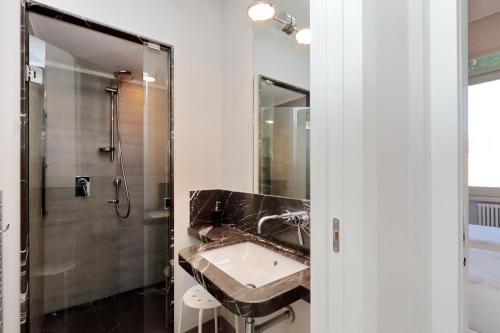 La salle de bains est pourvue d'un lavabo et d'une douche. dans l'établissement ROMANCE AL COLOSSEO 2, à Rome