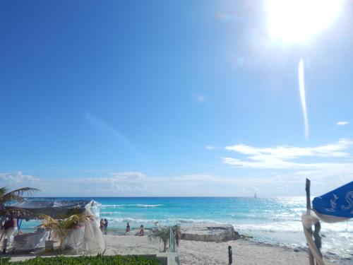 a beach with people on the sand and the ocean at Salvia Cancun Aparts in Cancún