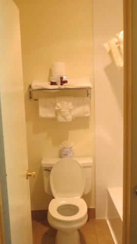 a bathroom with a white toilet and towels at Casa Lemus Inn in Raton