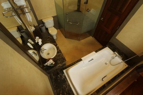 a bathroom with a sink and a toilet and a mirror at Bukit Merah Laketown Resort in Taiping