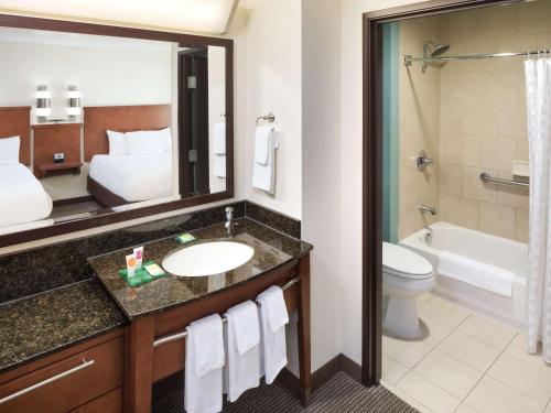 a bathroom with a sink and a toilet and a tub at Hyatt Place South Bend/Mishawaka in South Bend