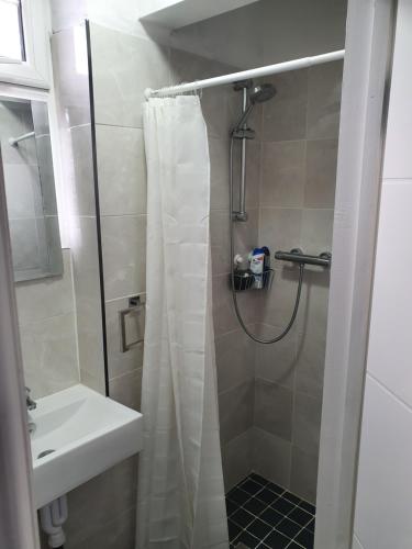 a bathroom with a shower curtain and a sink at Beautiful Rooms in Bury
