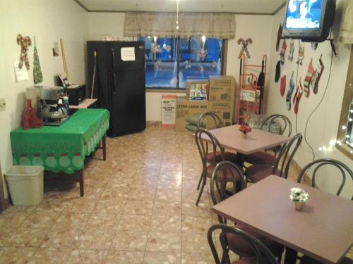 a restaurant with tables and chairs and a tv at Xenia Country Inn in Xenia