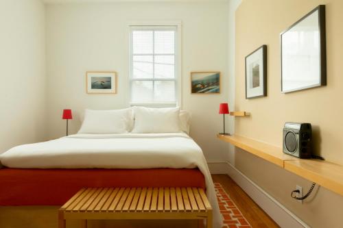 um quarto com uma cama, um banco e uma janela em THE STORE em Raleigh