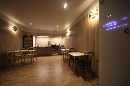 a dining room with tables and chairs and a kitchen at Hotel OU in Busan