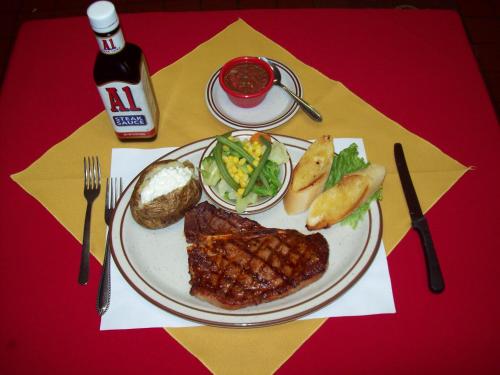 a plate of food with meat and vegetables on a table at Casa Lemus Inn in Raton