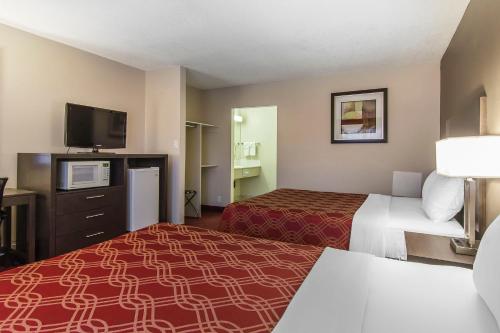 a hotel room with two beds and a flat screen tv at Econo Lodge Inn & Suites in Lethbridge
