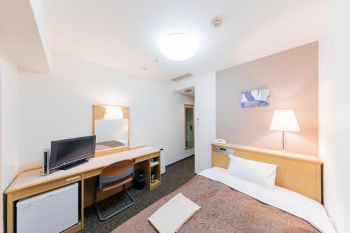 a hotel room with a bed and a desk at Sunny Stone Hotel in Osaka