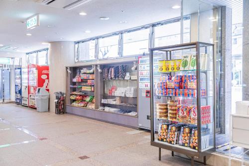 a grocery store aisle with a refrigerator in a store at Sunny Stone Hotel in Osaka