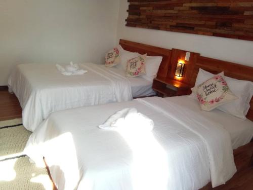 two beds in a room with white sheets at Ananda Resort in Panglao