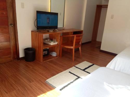 a bedroom with a desk with a television on it at Ananda Resort in Panglao