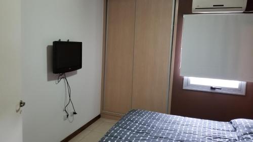 1 dormitorio con 1 cama y TV en la pared en Departamento en el Punto 0 de San Juan con Cochera en San Juan