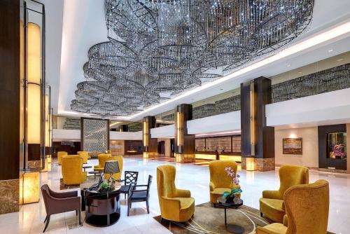 a lobby with chairs and a large chandelier at Hatten Hotel Melaka in Melaka