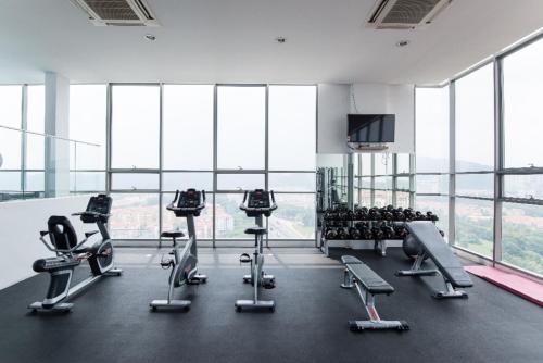 a gym with cardio equipment in a large room with windows at Madam Design 2 at Kota Damansara in Petaling Jaya
