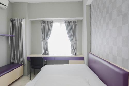 ein Schlafzimmer mit einem Bett und einem Fenster in der Unterkunft Comfortable 2BR Apartment at Taman Melati Margonda By Travelio in Depok