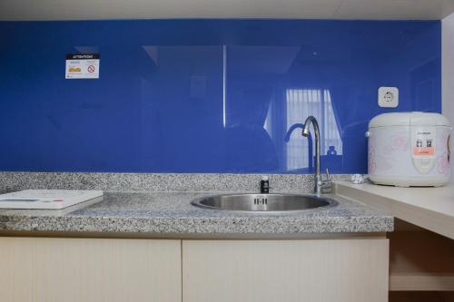 eine Küchentheke mit einer Spüle und einem Toaster in der Unterkunft Comfortable 2BR Apartment at Taman Melati Margonda By Travelio in Depok