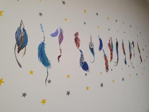 a group of feathers hanging on a wall with stars at Qlio Hotel in Kota Kinabalu