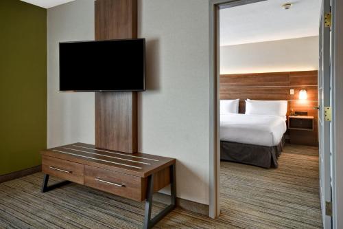 a hotel room with a bed and a flat screen tv at Holiday Inn Express Newport North - Middletown by IHG in Middletown