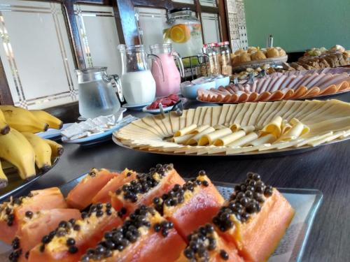 a buffet with plates of food on a table at Pousada Nanaco in Garopaba