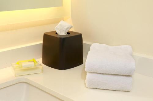 a bathroom with two towels and a box of tissues at Holiday Inn - Ciudad Juarez by IHG in Ciudad Juárez