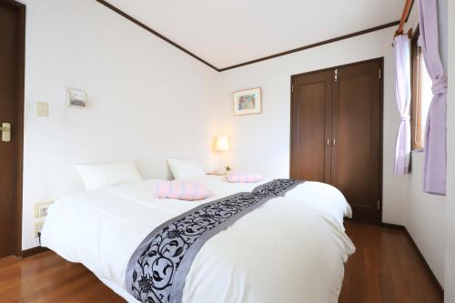 una camera da letto con un grande letto bianco con cuscini rosa di RKT4bedroom ForFamily 30mins Shibuya and Azabu a Tokyo