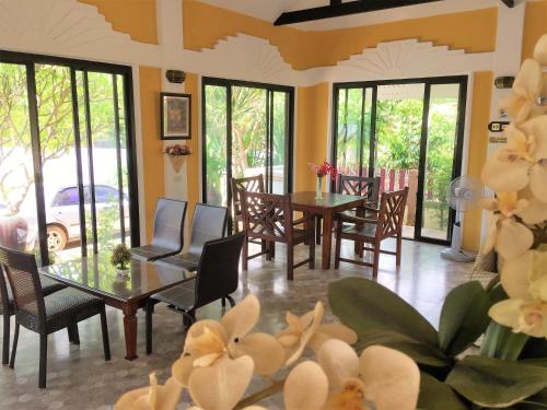 a dining room with tables and chairs and windows at Phu View Hideaway in Ban Kham Proi