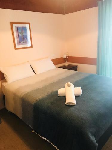 a bedroom with a bed with two towels on it at Lighthouse Beach Holiday Village in Port Macquarie