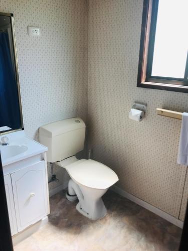 a bathroom with a toilet and a sink and a mirror at Lighthouse Beach Holiday Village in Port Macquarie