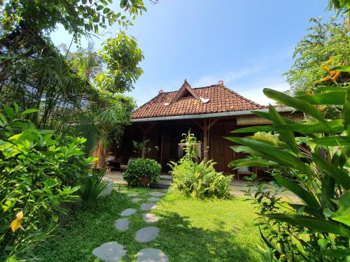una casa con un jardín delante de ella en Yabbiekayu Eco-Bungalows en Yogyakarta