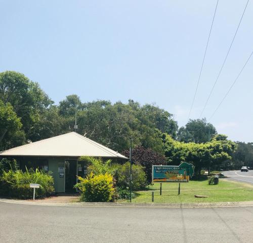 a building with a sign on the side of a road at Lighthouse Beach Holiday Village in Port Macquarie