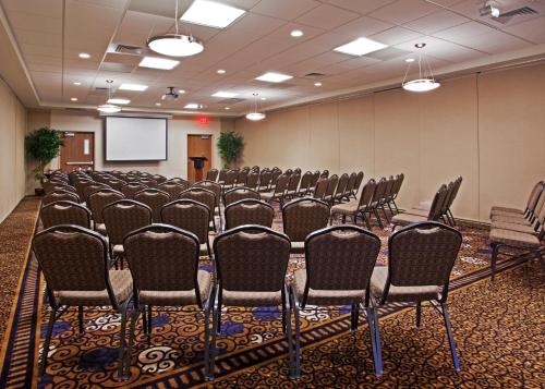 a conference room with rows of chairs and a screen at Holiday Inn Purdue - Fort Wayne by IHG in Fort Wayne