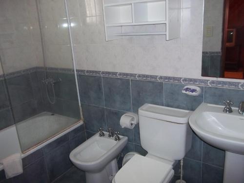 a bathroom with a white toilet and a sink at La Posada del Mar in Miramar