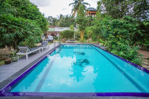 a swimming pool with blue water in a yard at Madoldu eco resort in Koggala