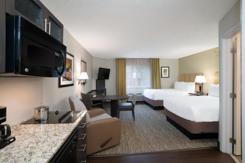 a hotel room with two beds and a living room at Candlewood Suites Hopewell by IHG in Hopewell