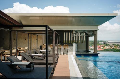 a resort with a pool and chairs and a swimming pool at Zuri Hotel in Iloilo City