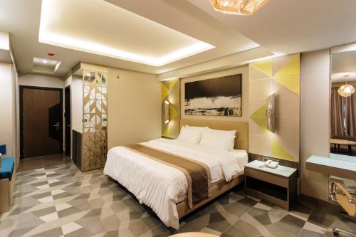 a hotel room with a bed and a tv at Zuri Hotel in Iloilo City