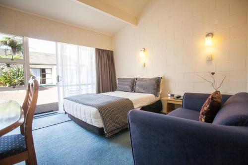 a hotel room with a bed and a couch at Kerikeri Court Motel in Kerikeri