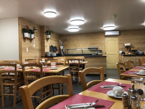a restaurant with tables and chairs and a kitchen at Hotel Crystal Interlaken in Interlaken