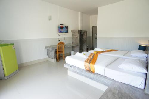 a bedroom with two beds and a desk in it at แกรนด์ ฟอเรสท์ Grand Forest in Chanthaburi