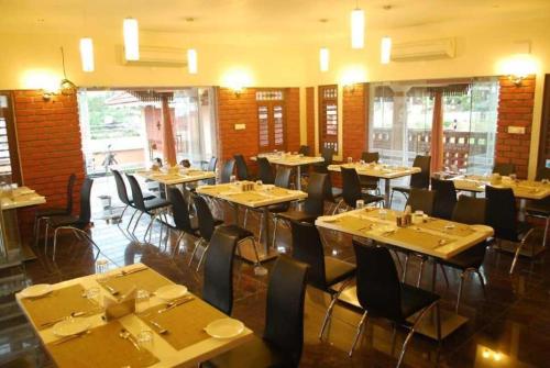 a dining room with tables and chairs in a restaurant at G S Resort in Velankanni