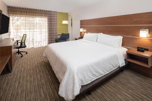a hotel room with a large bed and a desk at Holiday Inn Express Boca Raton - West by IHG in Boca Raton
